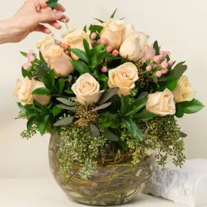 Cream colored roses in a round glass jar
