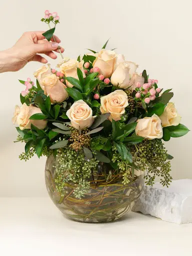 Cream colored roses in a round glass jar