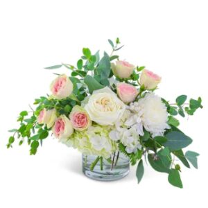White roses with leaves in a glass jar