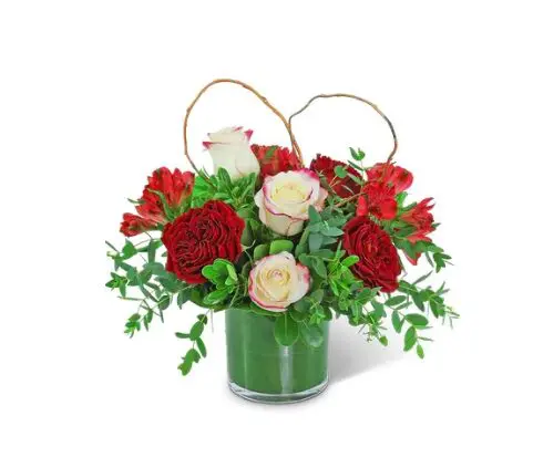 Red roses and white roses with leaves in a glass jar