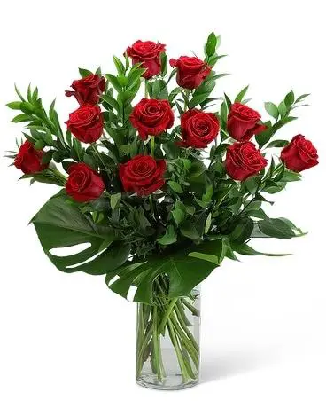 Red roses with stems and leaves in a glass jar