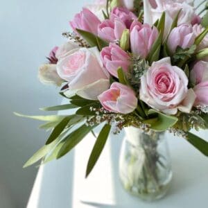 A beautiful bouquet of pink roses in a glass jar.